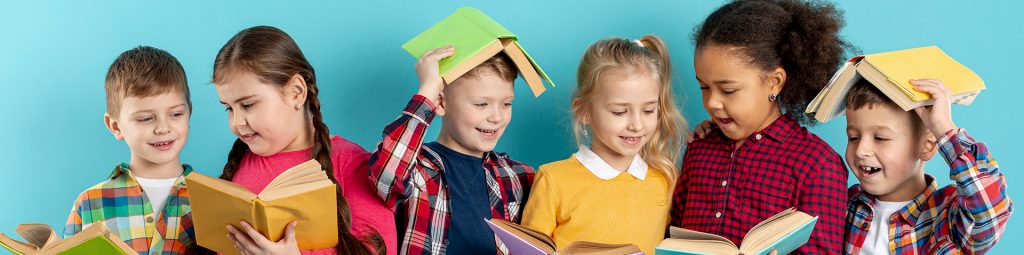 group of young kids with books ; some are reading and some have them on top of their heads