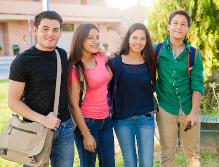 group of high school students outdoors with arms around each other